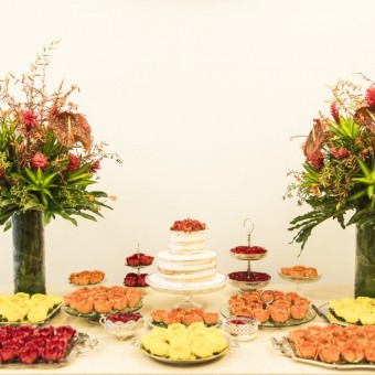 Arranjos de flores tropicais na mesa do bolo